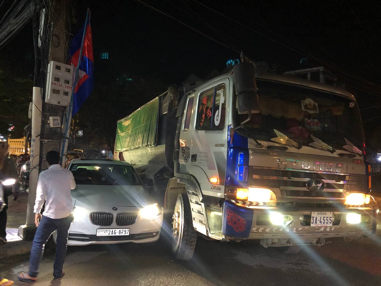 រថយន្តស៊េរីទំនើប BMW មួយគ្រឿង ត្រូវរថយន្តដឹកខ្សាច់បេីកកៀរទៅកៀបជាប់បង្គោលភ្លើងរងការខូចខាតយ៉ាងដំណំ